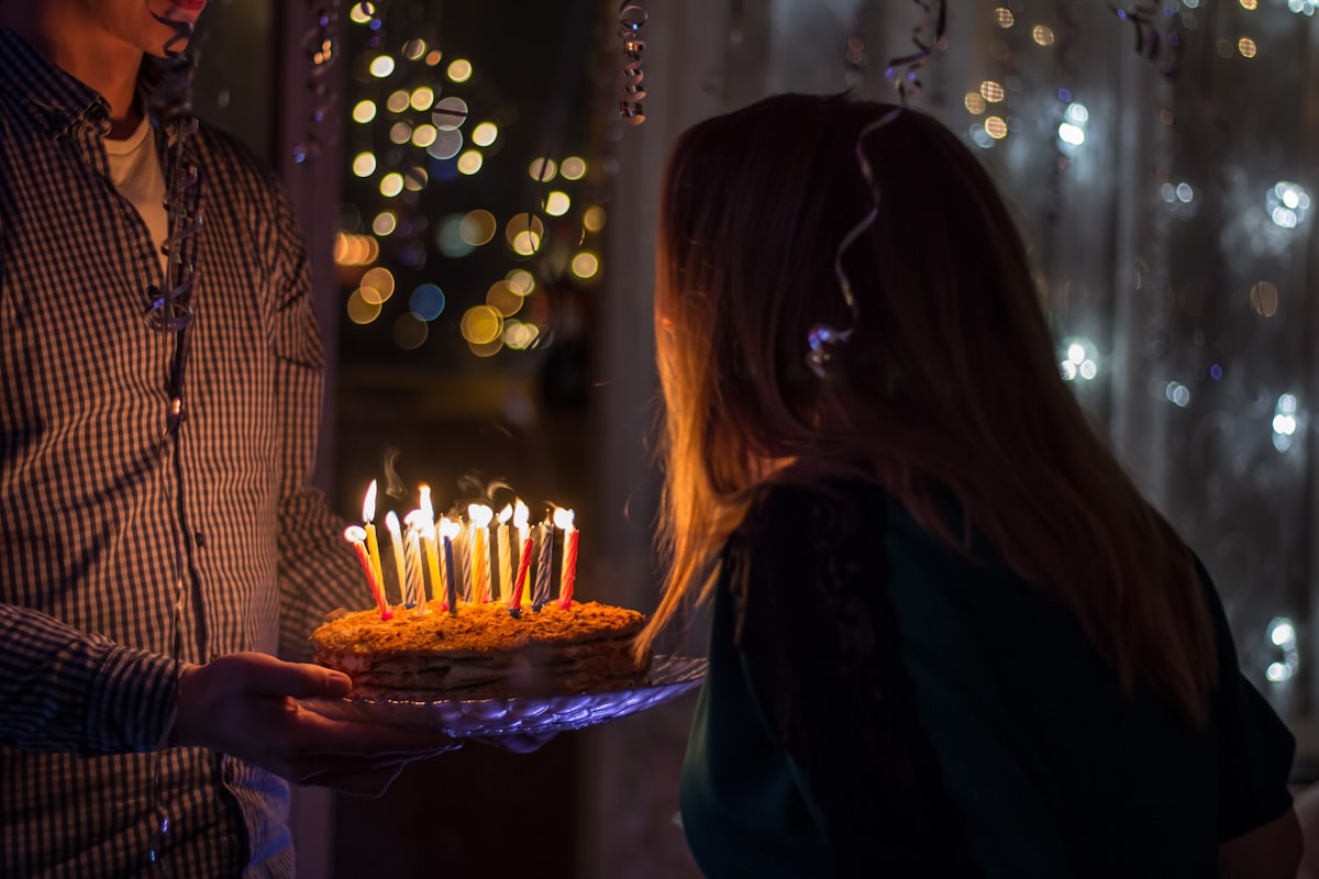 A birthday cake lit with candles, ready to be blown out